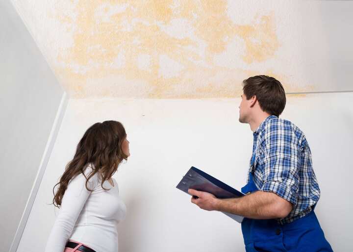 water damage repair expert doing an inspection with a woman that has water damage to her ceiling in Falcon, NC